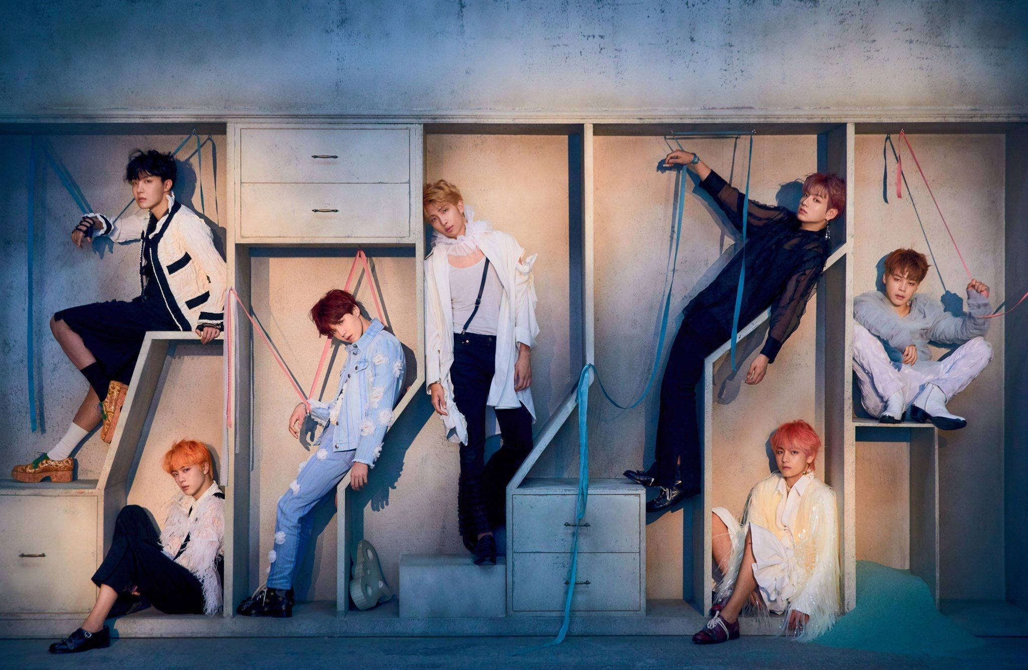 חברי BTS מצטלמים על מדפי ארון עם מחשב נייד טפט