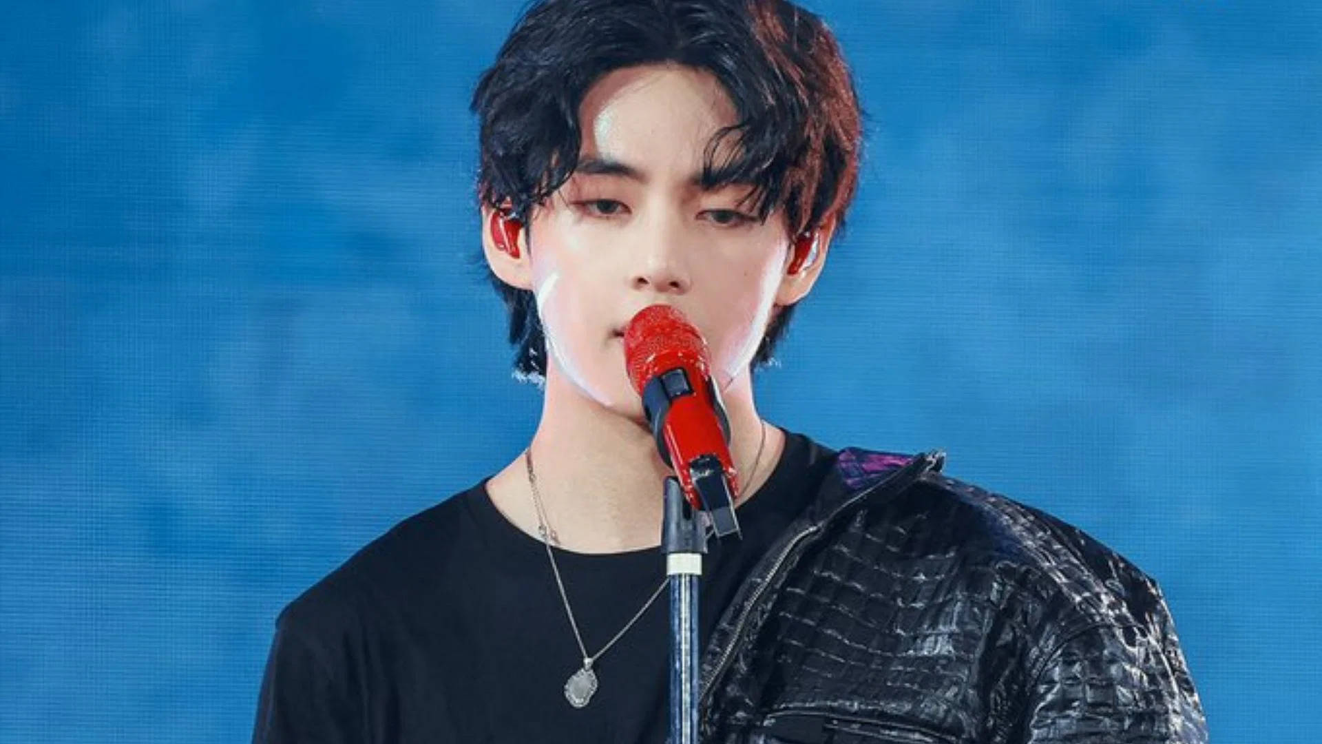 V מ-BTS עם מיקרופון אדום טפט