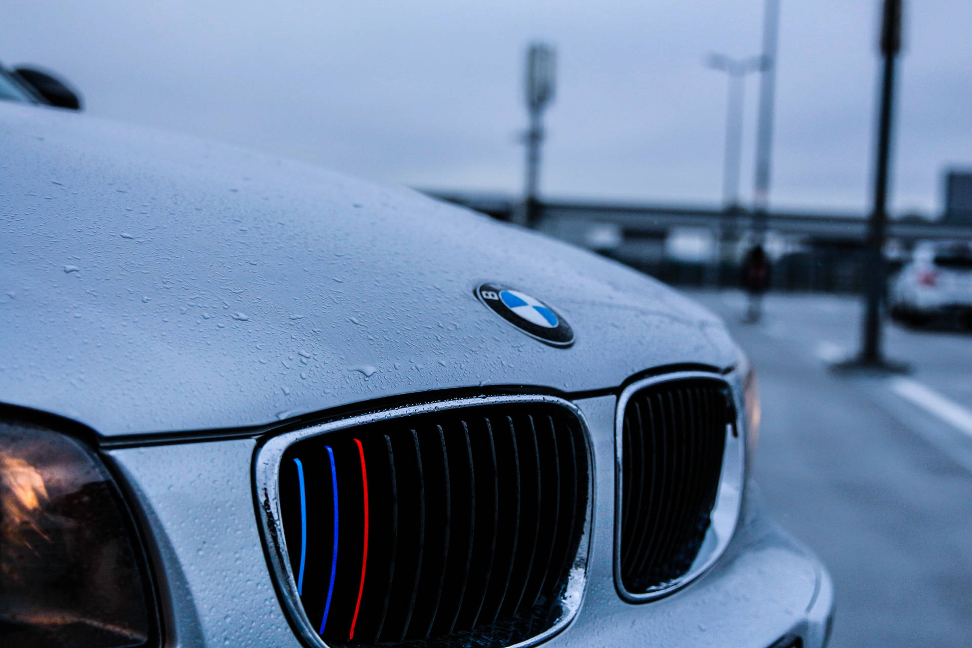 טפט תקריב של מכסה מנוע של מכונית BMW לבנה עם טיפות גשם