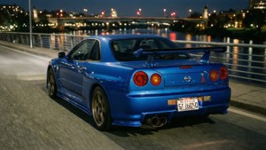 טפט ניסאן GT-R כחולה על גשר בלילה עם השתקפויות של העיר.