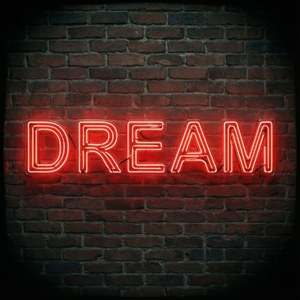 שלט ניאון אדום מעורר השראה עם הכיתוב DREAM על קיר לבנים.